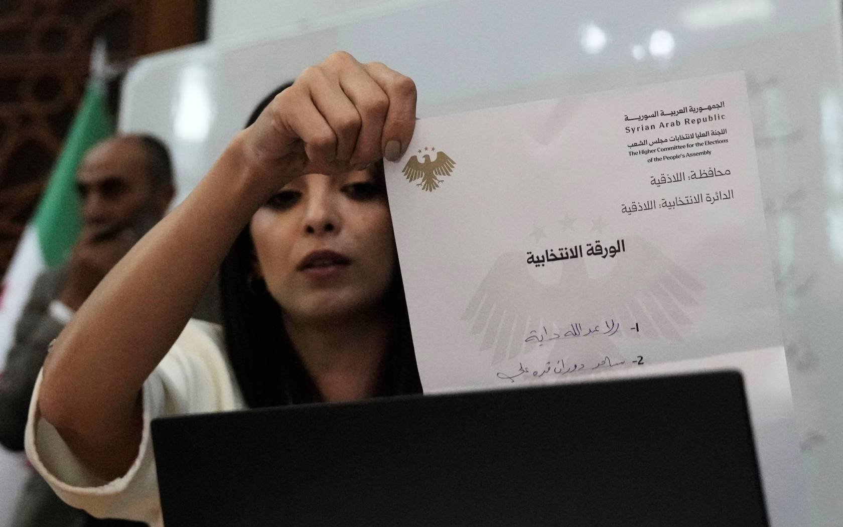 A Syrian election official shows a ballot paper during the counting of ballots in Latakia, Syria, on Sunday, 5 October, 2025.