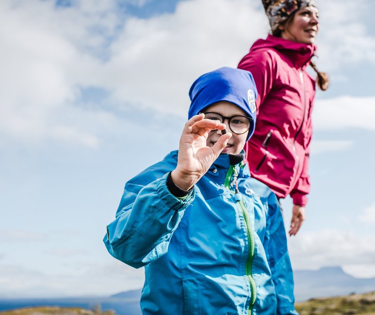 en pojke visar upp en liten sten mellan tummen och pekfingret p&aring; Fj&auml;lles stig