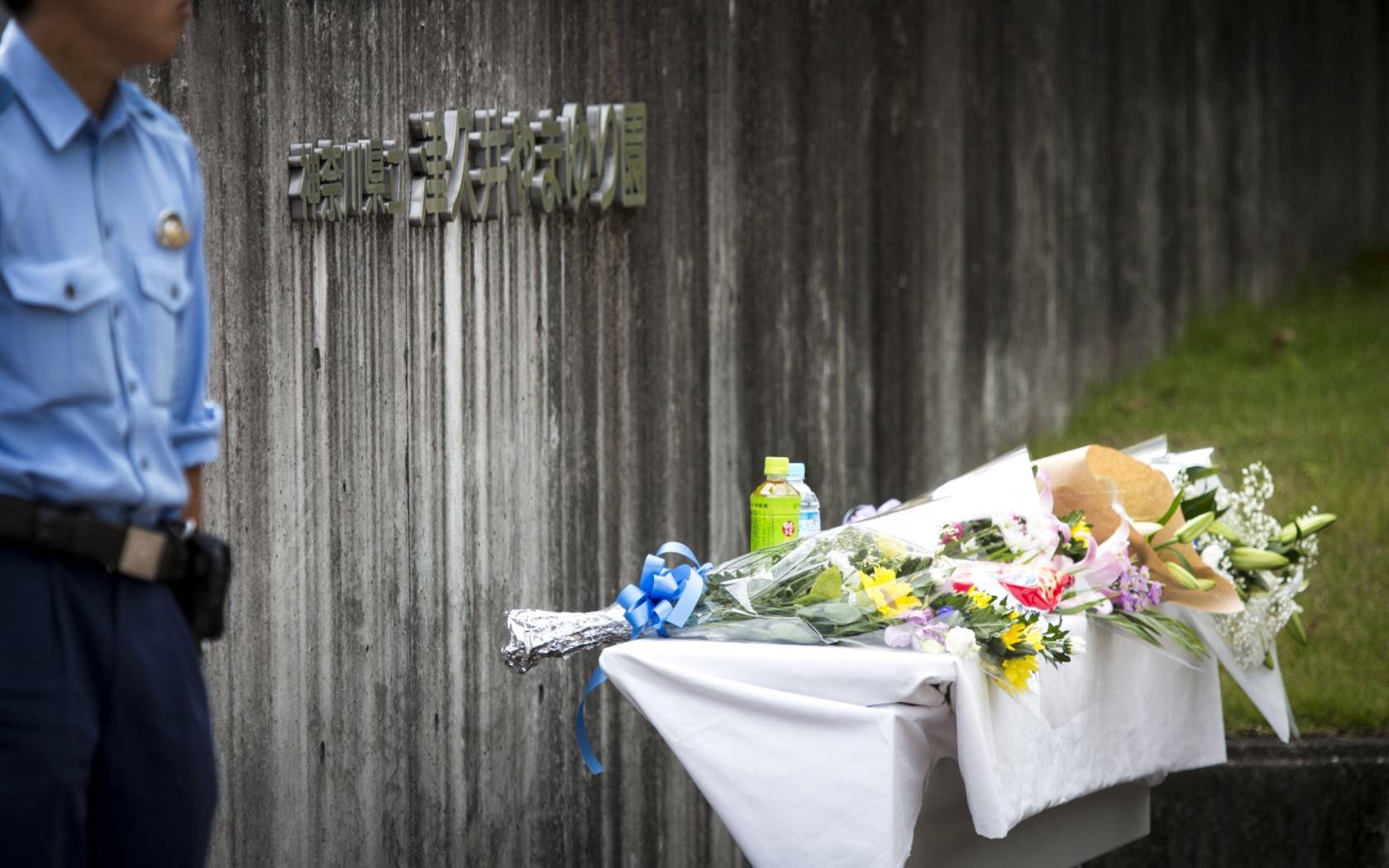 A flower and offering is seen in front of the entrance of the Tsukui Yamayuri-en building at Sagamihara.