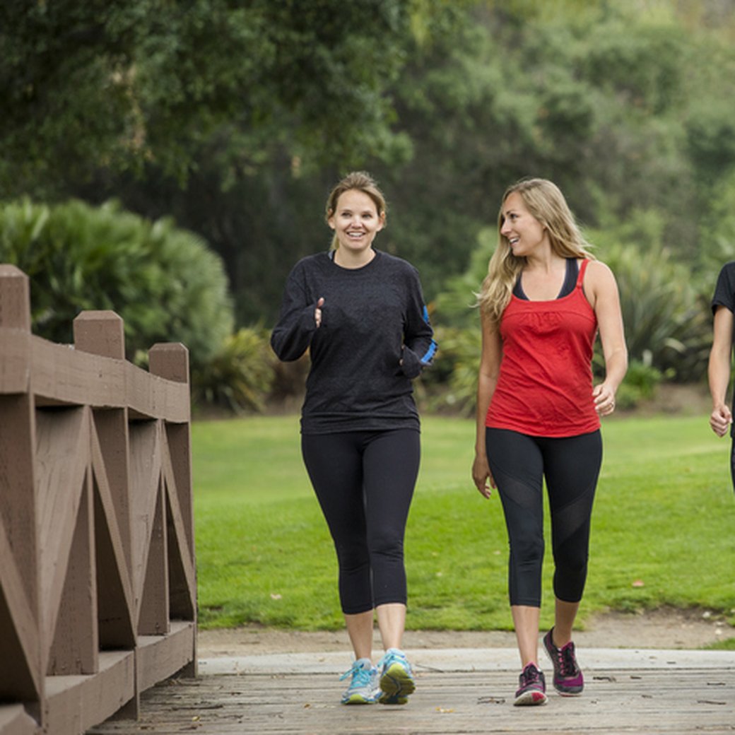 Group women in their 30s walking together in the outdoors.