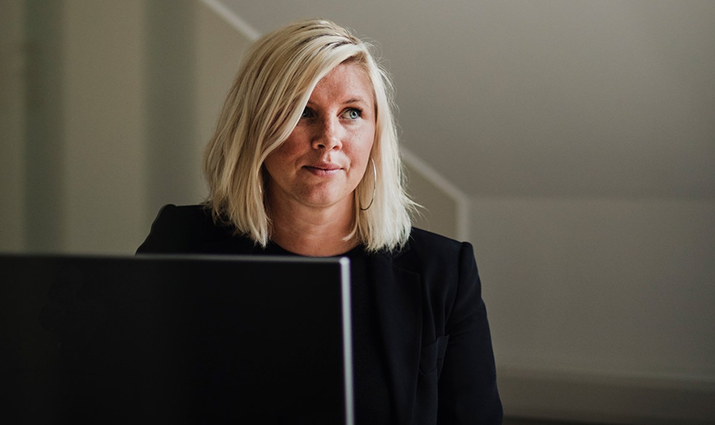 Linnea Ibrahimovic sitter framf&ouml;r en datorsk&auml;rm, hon tittar &aring;t ett annat h&aring;ll. Datorn syns i f&ouml;rgrunden.