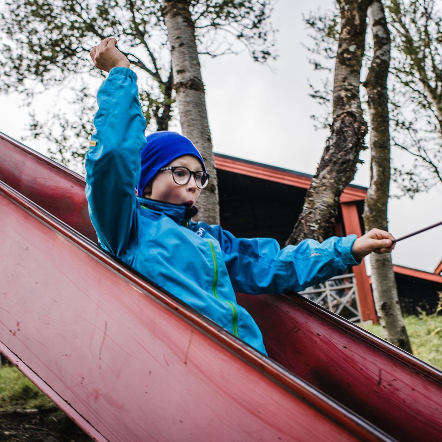 pojke svischar ned f&ouml;r en rutschkana
