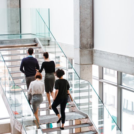 Rear view of group of young businesspeople walking up the stairs.