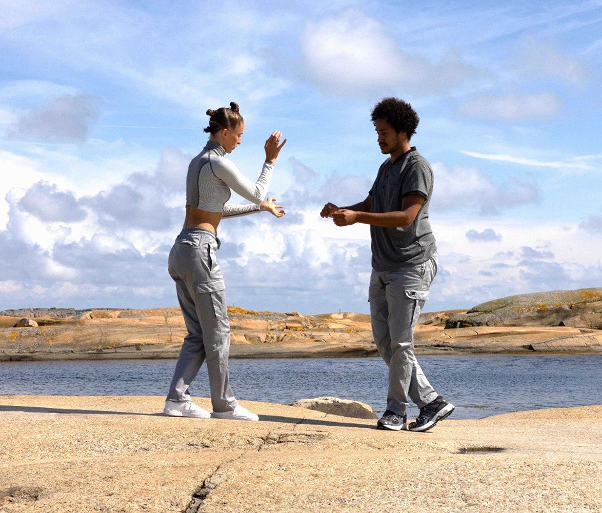 De två dansarna ur gruppen Land before time, dansar på klippor vid havet.