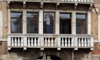 Restorer working inside a building along the Grand Canal, Venice, Italy.