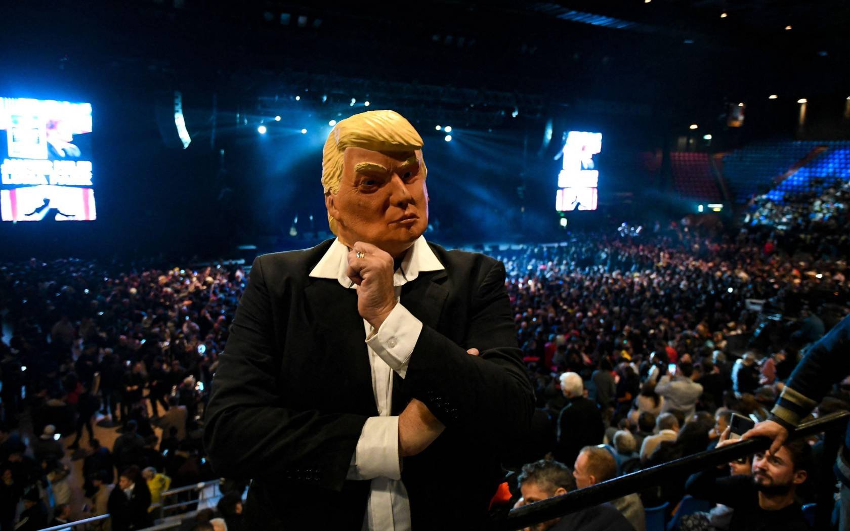 A supporter of Argentinian President Javier Milei wears a Donald Trump mask at a rally.