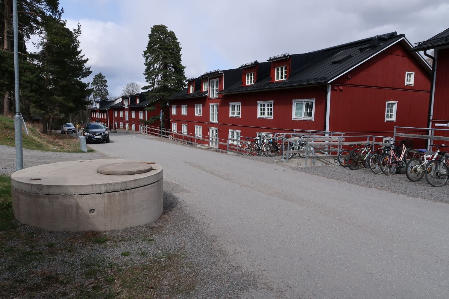 Exterior of red, three story buildings with bicycle parking outside.