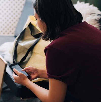 Woman using mobile phone while sitting in new home