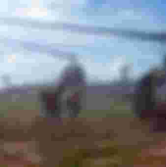 Photograph of American troops running towards a chopper during the Vietnam War.