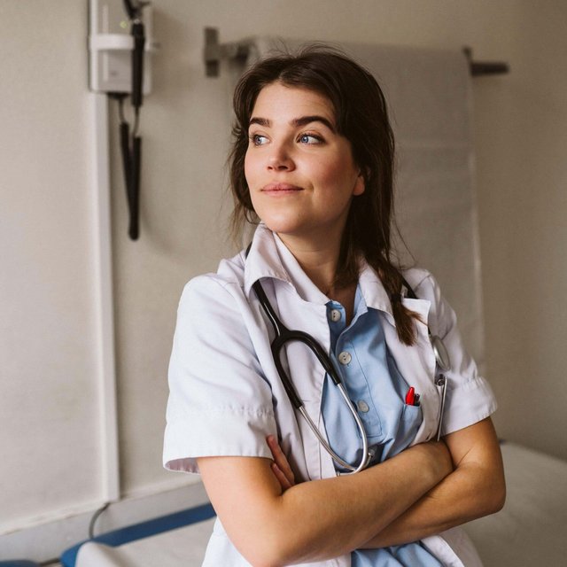 Female medical expert standing with arms crossed looking away