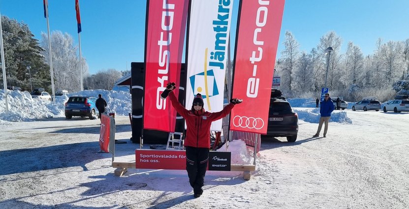 Fanny Sjödin, hållbarhetschef på Skistar, framför den tillfälliga laddstationen i Ljusdal. Foto: Jimmy Anjevall
