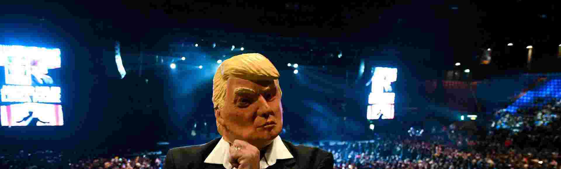 A supporter of Argentinian President Javier Milei wears a Donald Trump mask at a rally.