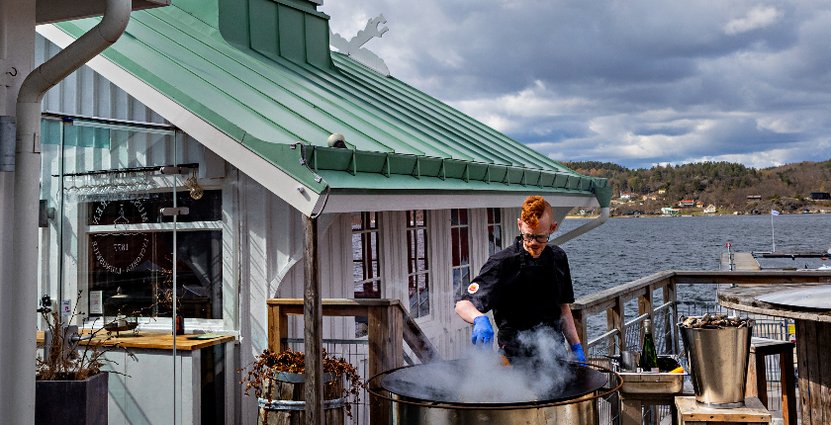 Kocken Fredrik Hjärthammar fräser musslor på uteserveringen.  Foto: Linn Bergbrant