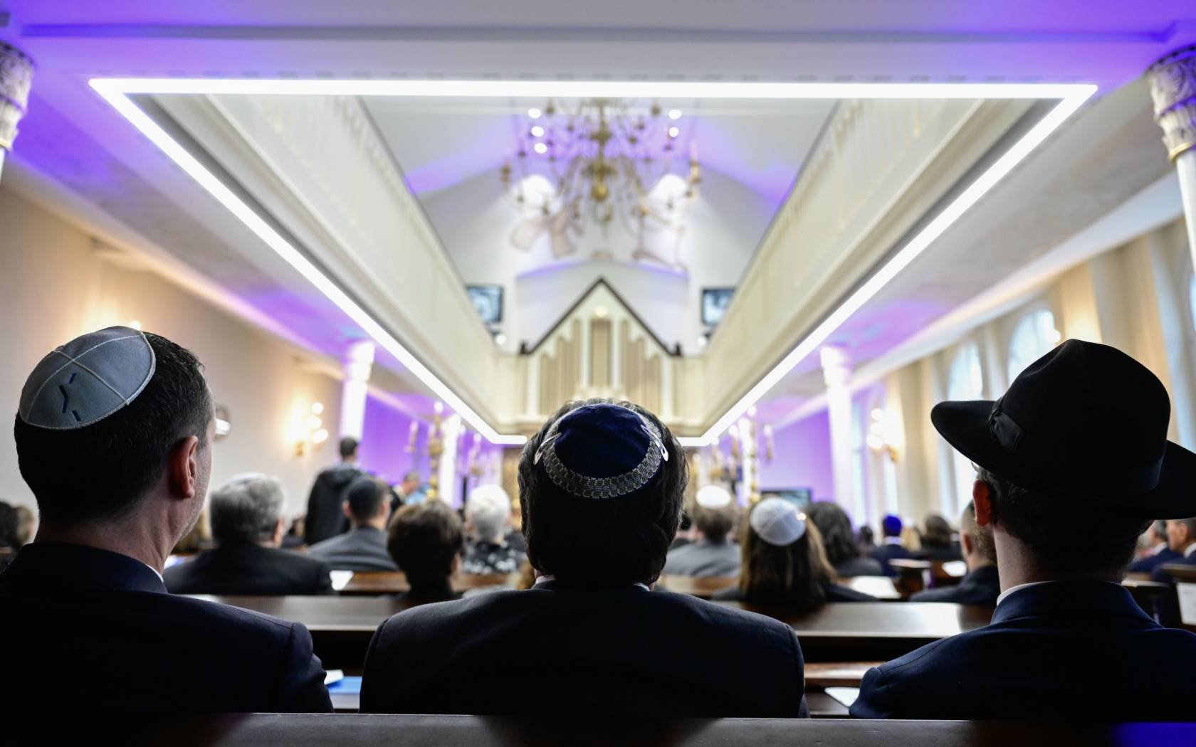 People take part in a commemoration of the 85th anniversary of Kristallnacht in the Beth Zion synagogue.