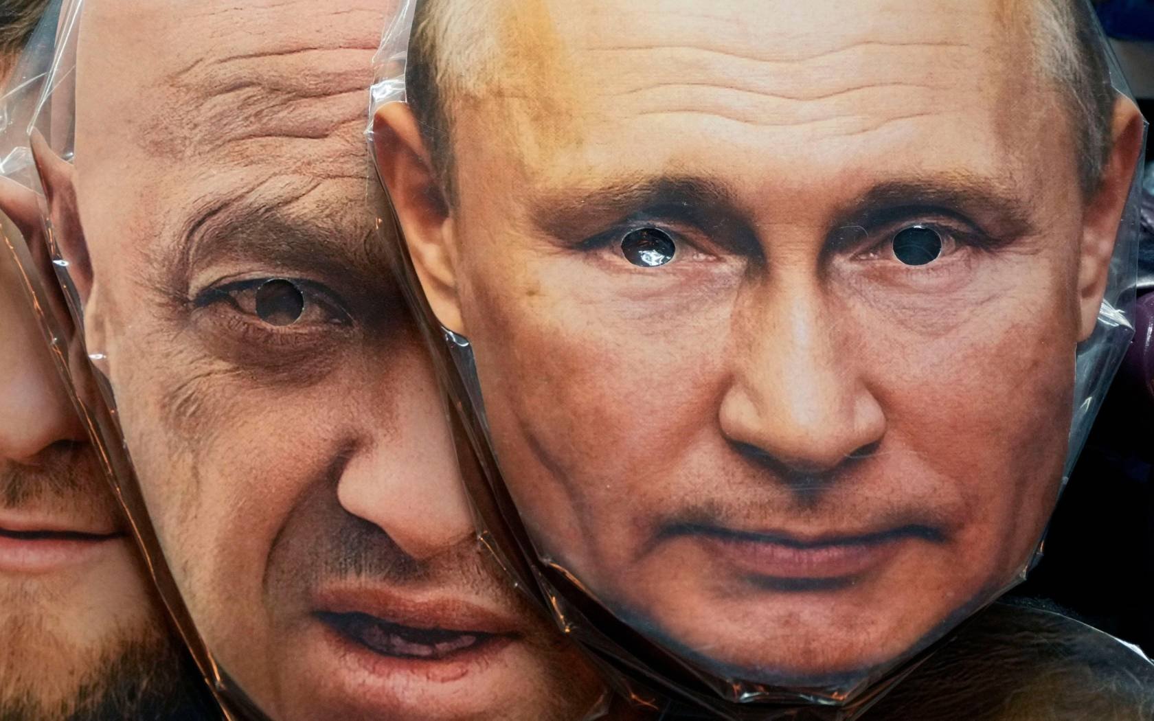 Face masks depicting Russian President Vladimir Putin, right, and Yevgeny Prigozhin are displayed for sale at a souvenir shop in St. Petersburg.
