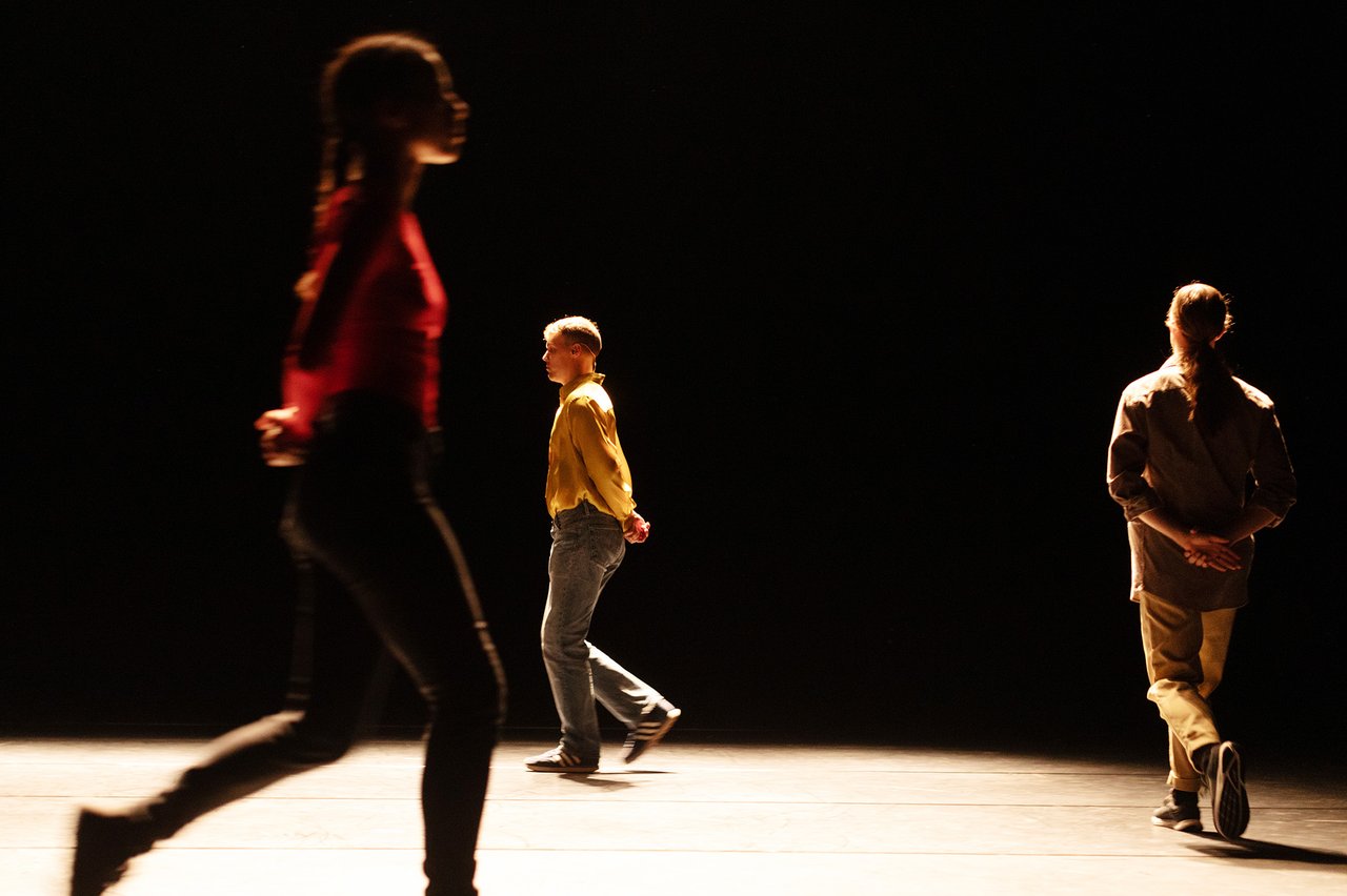 Tre dansare går runt på en scen.