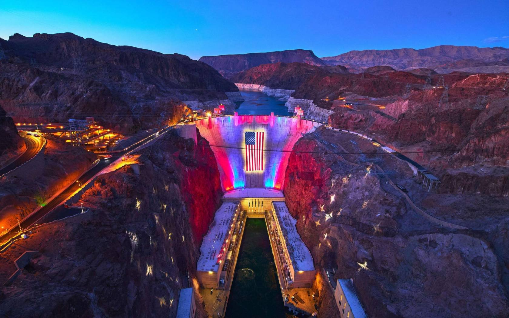 The Hoover Dam in Nevada lit up with the United States flag.
