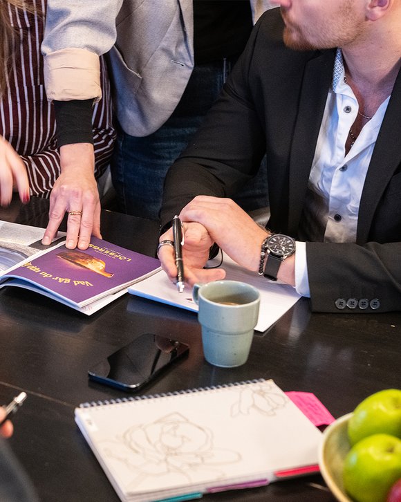 ett arbetslag under konferens kollar p&aring; ett magasin