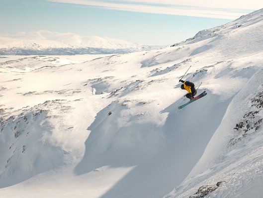 A skier performs a jump off-piste