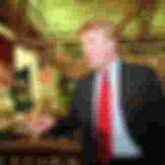 Donald Trump poses for photos above the floor of the New York Stock Exchange after taking his Trump Plaza Casino public in New York on June 7, 1995.