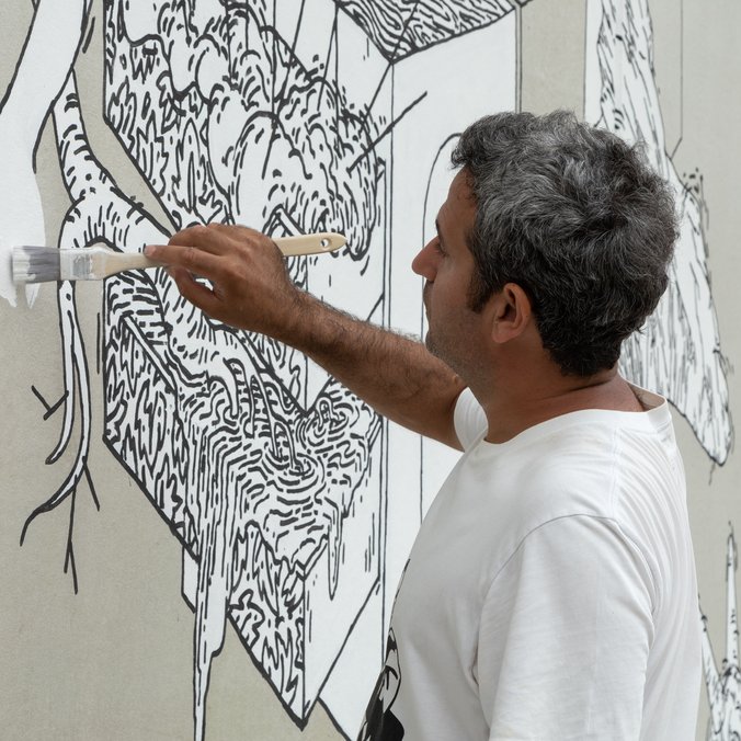 Närbild när Muhammad Ali skapar väggmålningen Under stenen.