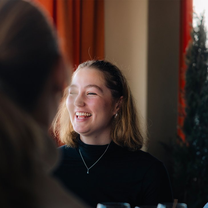 close-up of a young woman laughing in a restaurant
