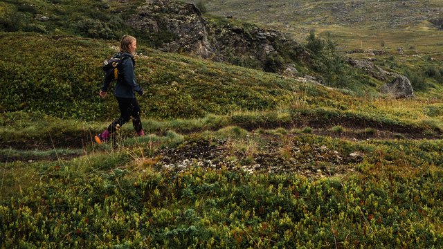 kvinna vandrar bland dimmiga bergstoppar