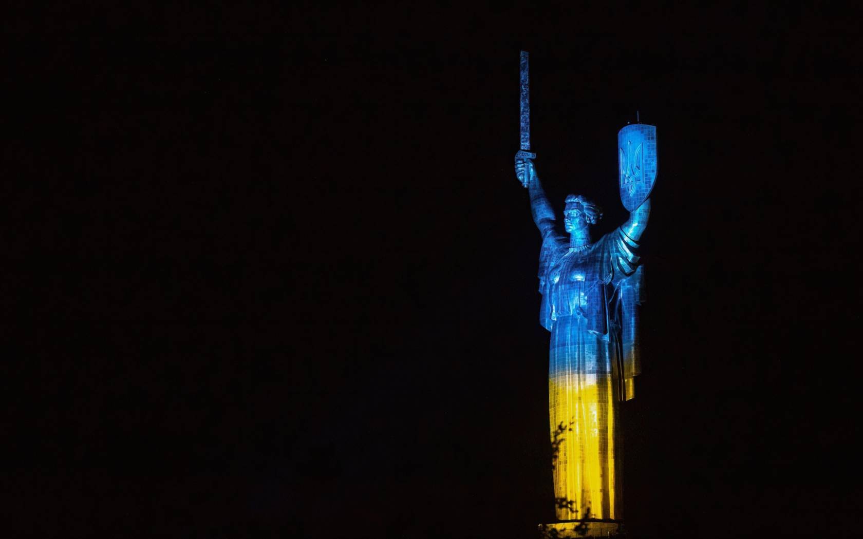 The Motherland monument in Kyiv illuminated with the colours of the Ukrainian flag.