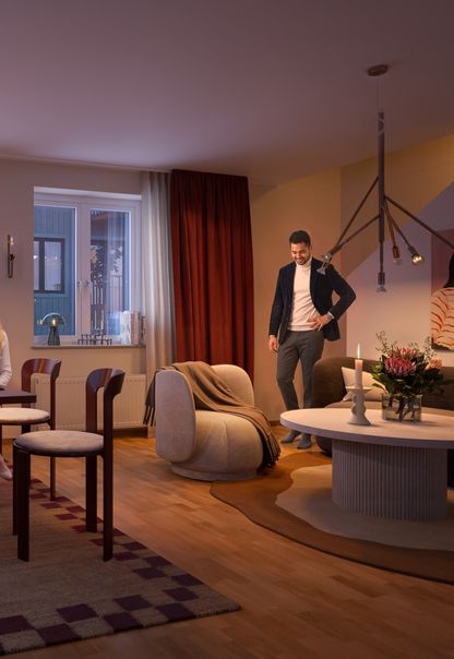 En grupp människor som sitter i ett vardagsrum i Hebas hyreslägenhet i Smedjan Källberga.