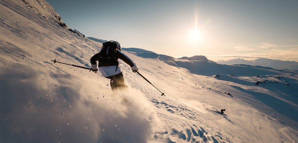 sn&ouml;n yr bakom en skid&aring;kare som &aring;ker offpist i solen