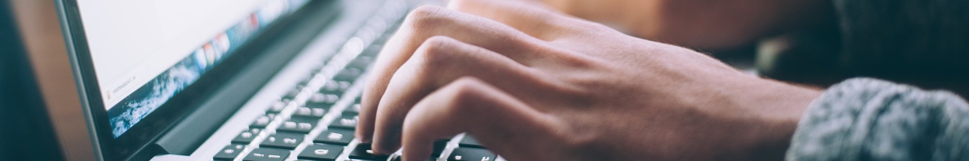 Händer som skriver på tangenter på en laptop
