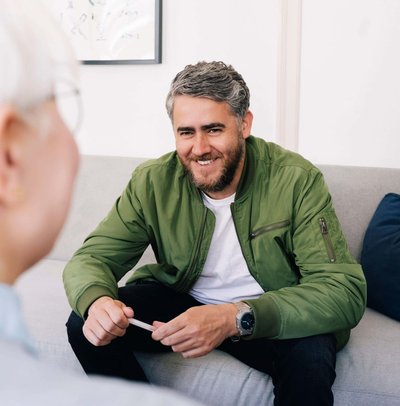 Leende man som pratar med en kvinnlig psykoterapeut på ett terapikontor