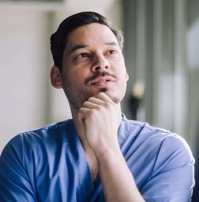 Low angle view of male healthcare professional with hand on chin at hospital