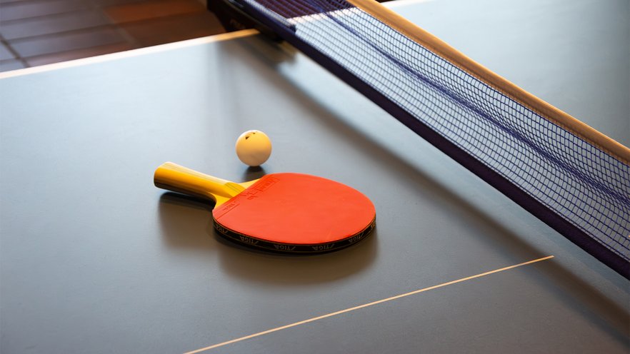 pingisracket och boll p&aring; ett pingisbord