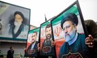 Mourners hold up posters of the late Iranian President Ebrahim Raisi in Tehran, 21 May 2024.