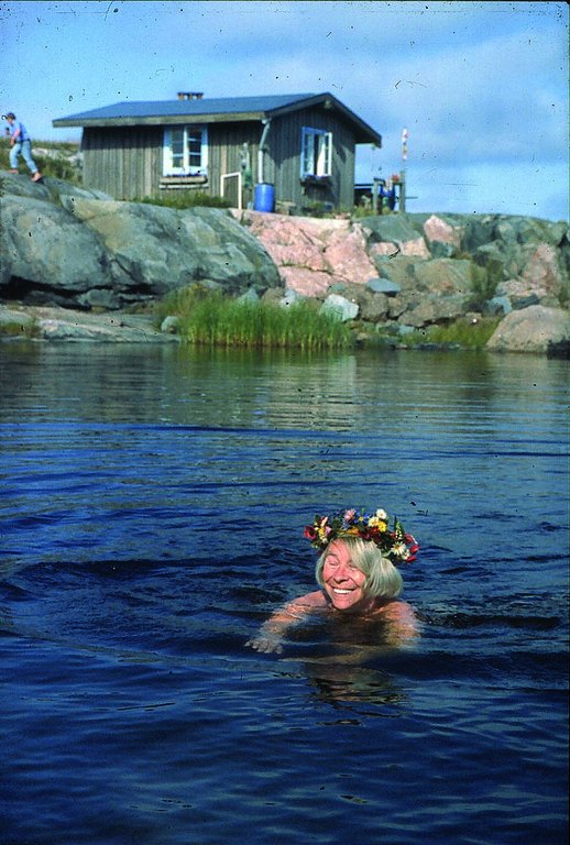 Tove simmar på Klovharun. I bakgrunden syns Tuulikki Pietilä. Foto: ©Moomin Characters™