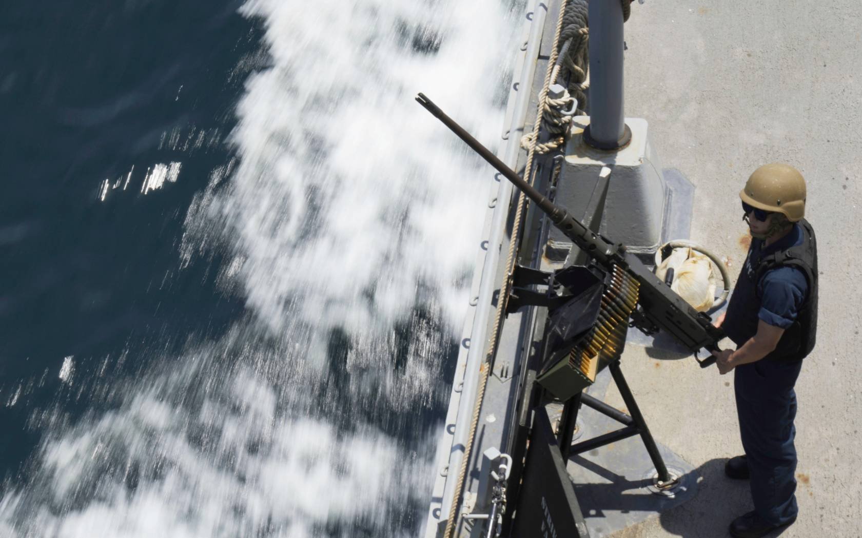A US Navy sailor stands by a machine gun aboard the USS Paul Hamilton in the Strait of Hormuz, 19 May 2023.