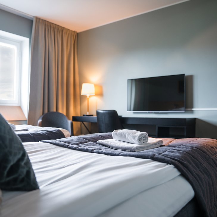dubbelrum p&aring; Hotell Riksgr&auml;nsen med vikta handdukar p&aring; s&auml;ngarna