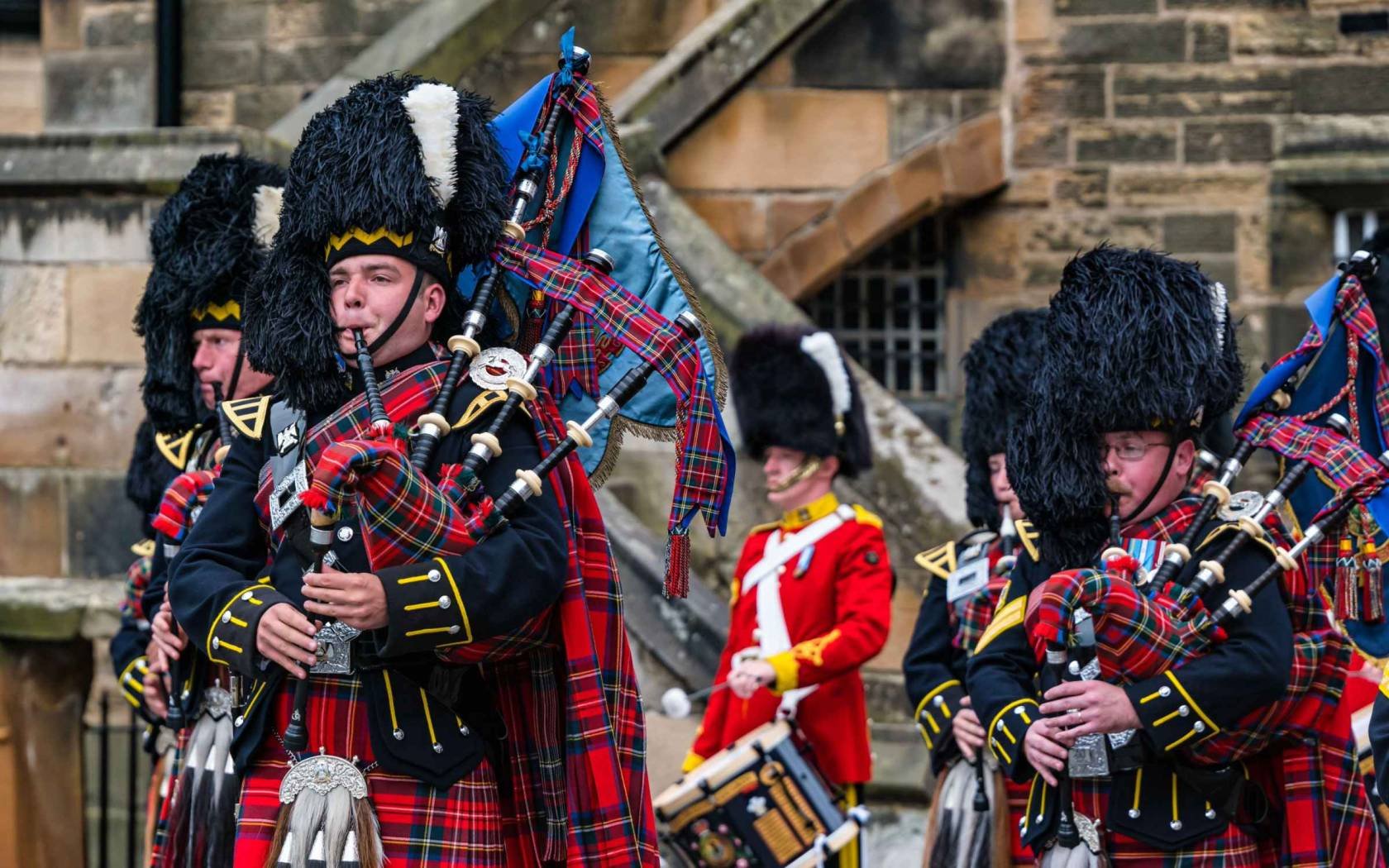 Royal Scots Guards military pipers playing bagpipes in kilt uniforms at Edinburgh Castle in a military ceremony, Scotland, UK.