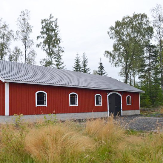 Stallbyggnad med välvda fönster och portar
