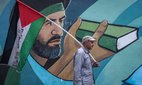 An Iranian man holds a Palestinian flag at an anti-Israel protest.