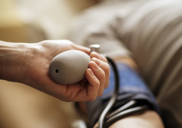 Hand som mäter blodtryck på patient