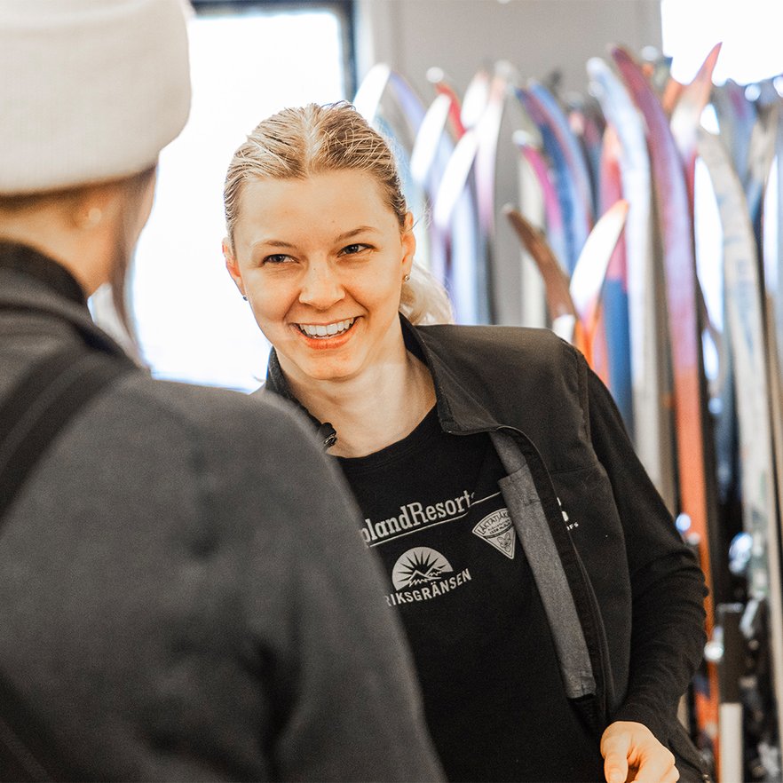 A female employee greets a customer in the sports shop
