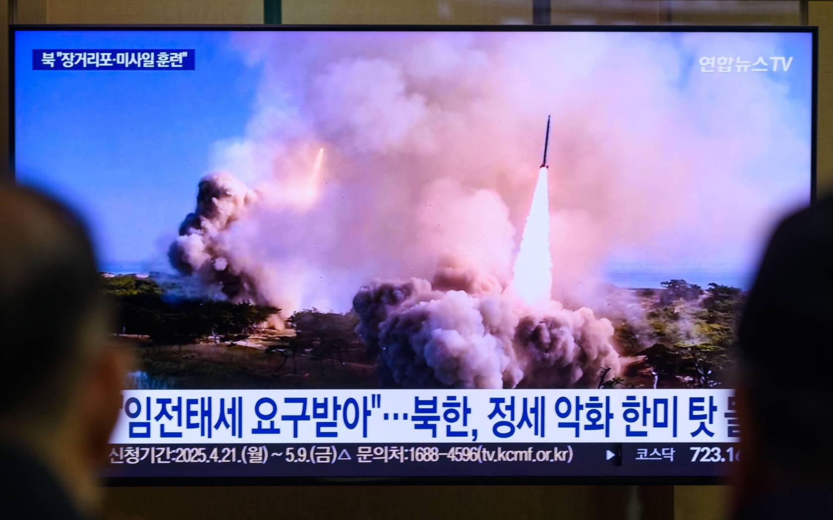 South Korean citizens watch North Korean military exercises.