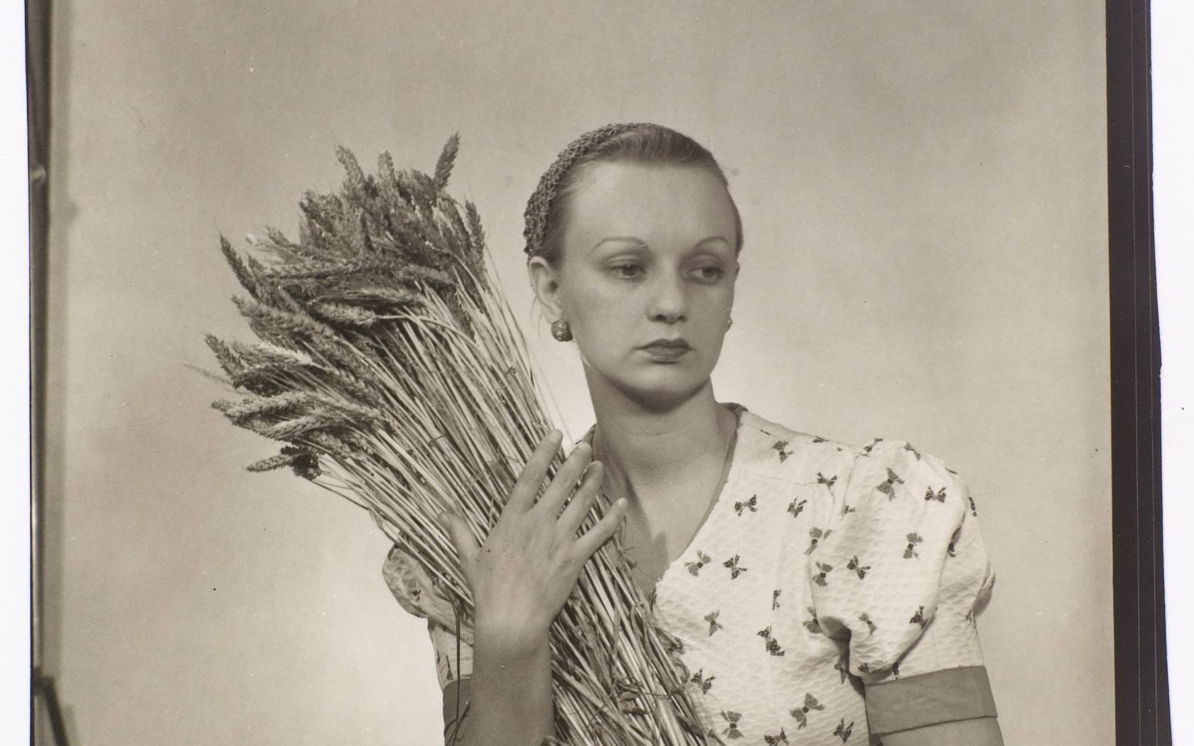 Portrait of Ithell Colquhoun holding a bundle of a wheat taken by Man Ray