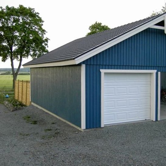 Blått garage med carport på sidan
