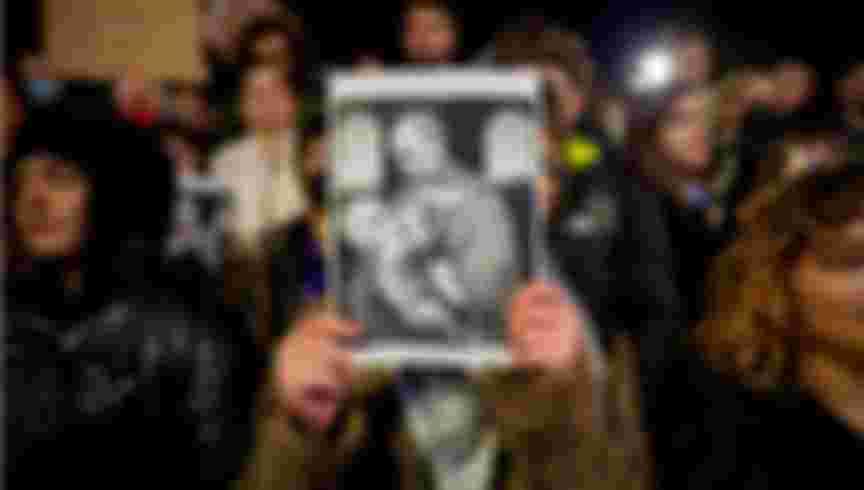 A protestor in Romania holds an image of Russian President Vladimir Putin and Calin Georgescu, the independent candidate for Romanian presidency who won the first round of elections