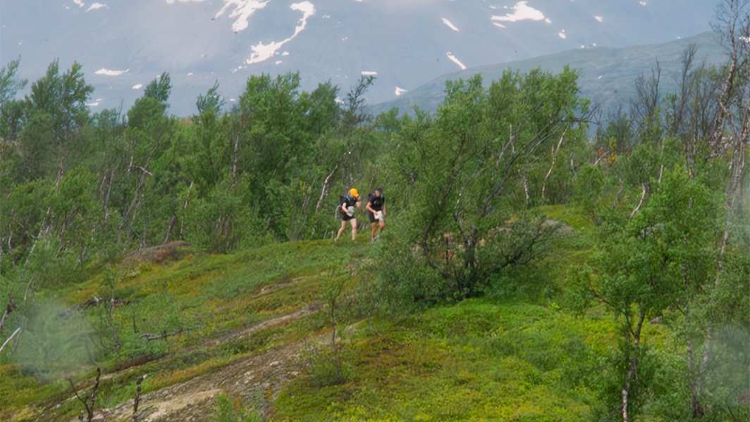 två tävlande bland höga fjälltoppar