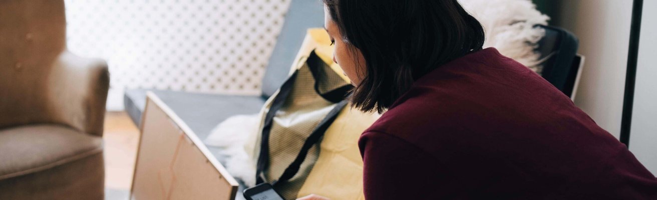 Woman using mobile phone while sitting in new home
