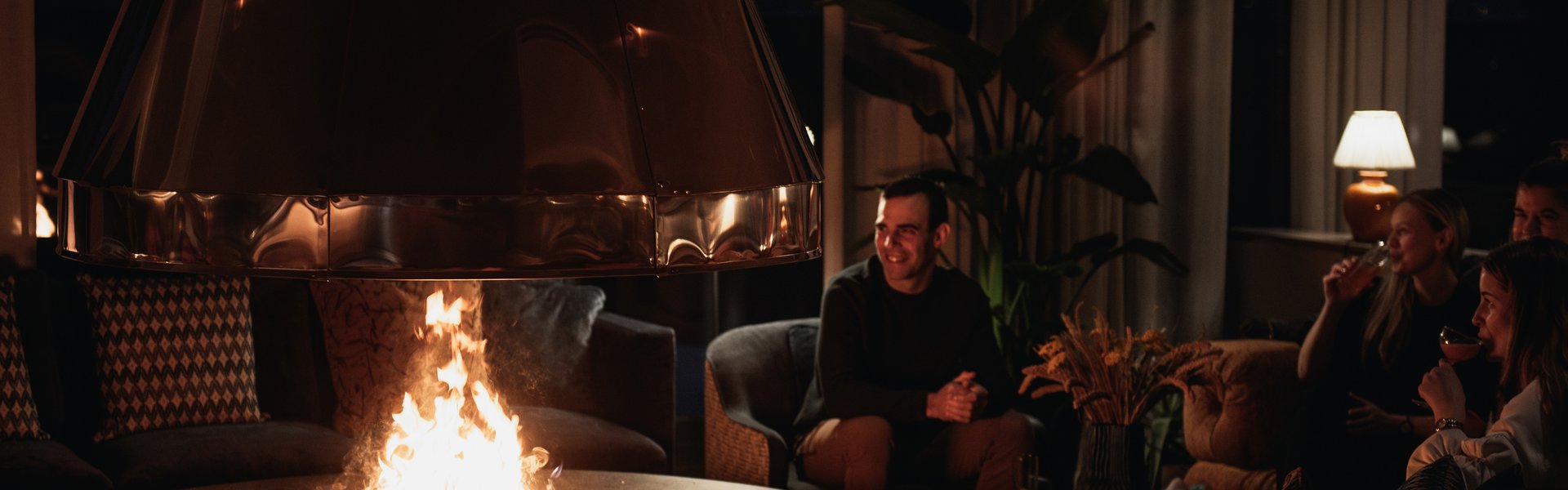 Fyra personer sittandes vid eldstaden